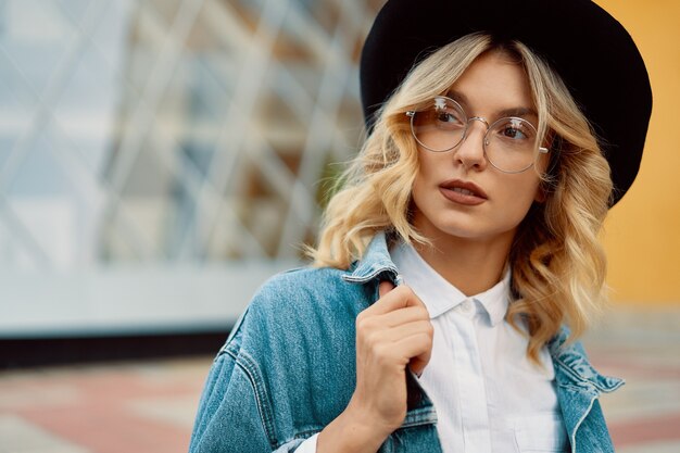 portret mooie vrouw met bril en een hoed buiten