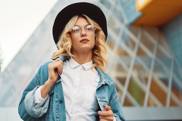 portret mooie vrouw met bril en een hoed buiten