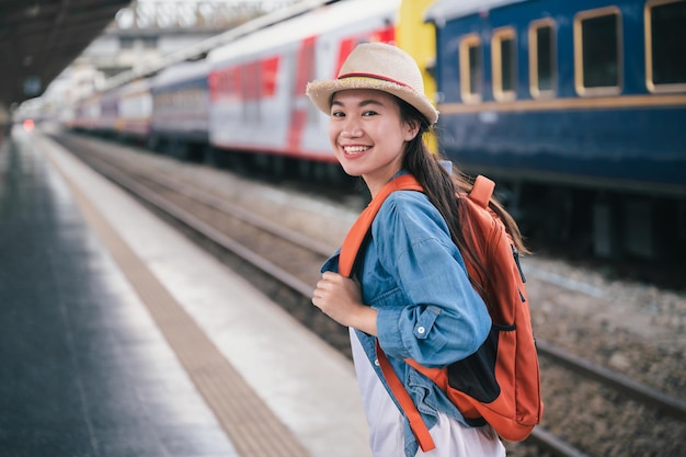 Portret mooie vrouw reiziger toerist met tas pack op treinstation