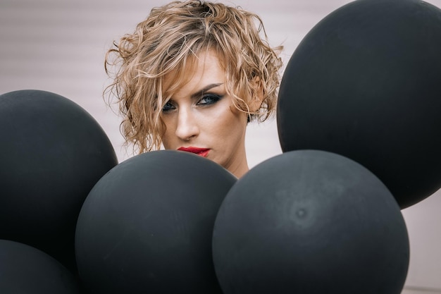 Portret mooie vrouw van model uiterlijk met donkere ballonnen Kunst schieten vanuit ongebruikelijke hoeken