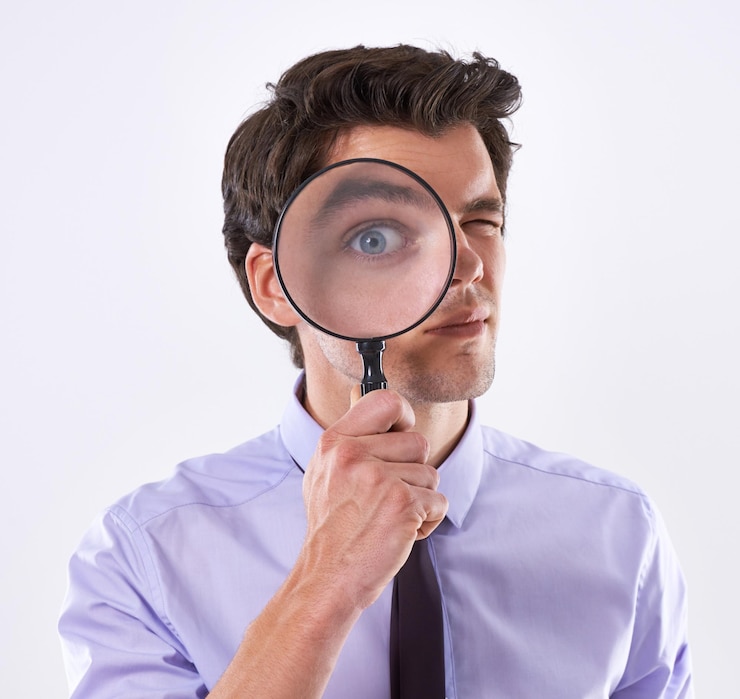 Foto portret oog en zakenman met vergrootglas onderzoeker en audit bij bedrijf op witte studio achtergrond gezicht mannelijke werknemer en pi met naleving en eerlijke handel bewijs of informatie