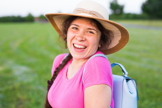 Portret op leuke grappige lachende vrouw met sproeten in hoed in de natuur