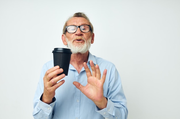 Portret oudere man met een zwart glas in zijn handen een drankje geïsoleerde achtergrond