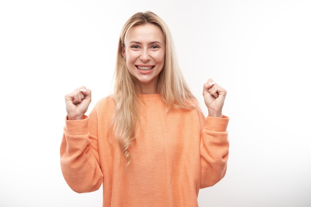 Portret positief blond meisje verheugt zich emotioneel en voelt zich gelukkig tevreden geïsoleerd op een witte achtergrond reclamebanner