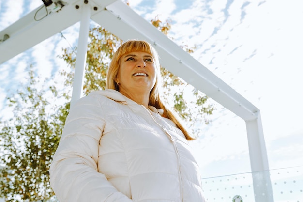 Portret roodharige vrouw van middelbare leeftijd tegen een wazige achtergrond van het stadsbeeld