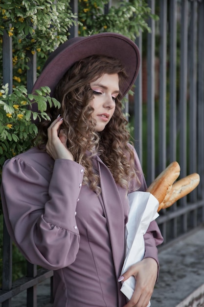 Portret schattige jonge vrouw in Franse stijl met stokbrood in handen