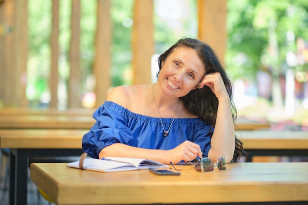 Portret senior vrouw die lacht, genietend van een mooie zonnige dag in een café buiten