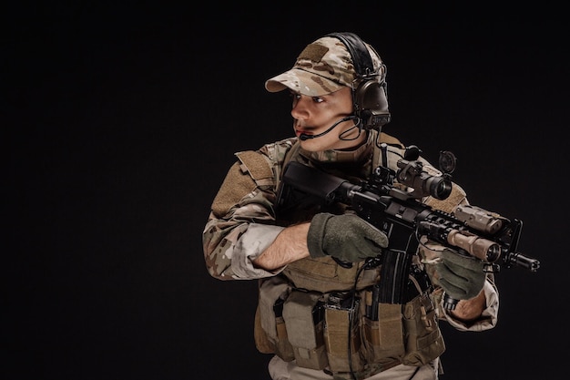 Portret soldaat of particuliere militaire aannemer met sniper rifle oorlog leger wapen technologie en mensen concept afbeelding op een zwarte achtergrond