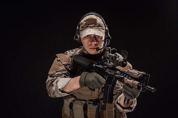 Portret soldaat of particuliere militaire aannemer met sniper rifle oorlog leger wapen technologie en mensen concept afbeelding op een zwarte achtergrond