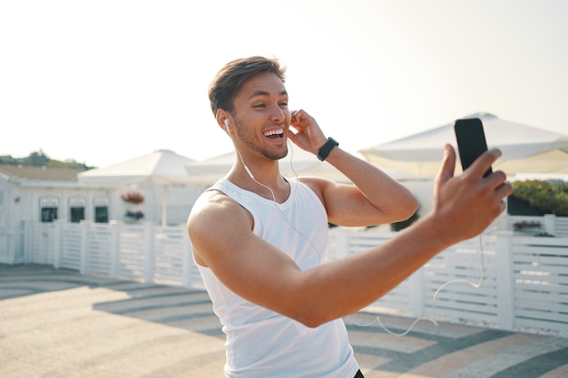 portret sportieve man met mobiel chatten online video