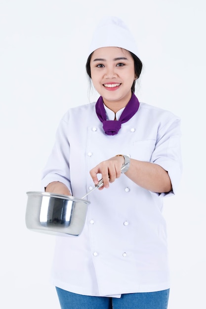 Portret studio shot van Aziatische professionele restaurant koken vrouwelijke chef-kok in uniform van de kok en sjaal staande glimlachend kijken naar camera met roestvrij pot en deksel op witte achtergrond.