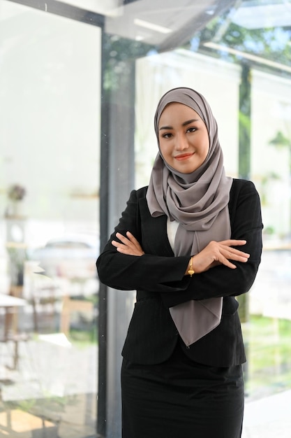 Portret Succesvolle Aziatische moslim zakenvrouw staat op kantoor met haar armen gekruist
