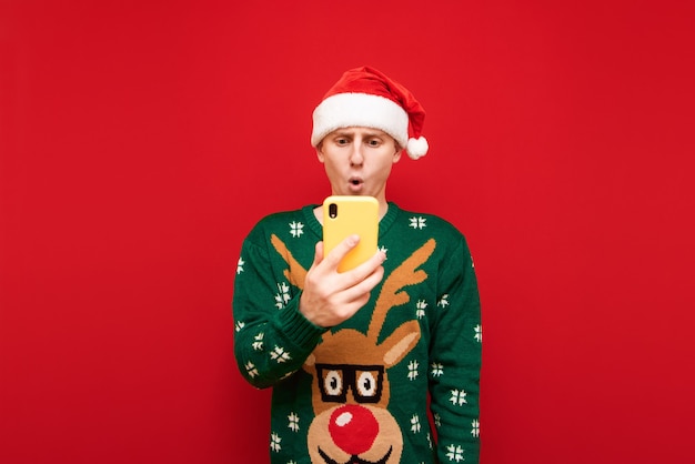 Portret tiener jongen met kerst trui met telefoon