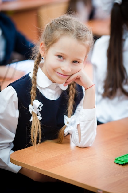 Portret van aanbiddelijk klein schoolmeisje in klaslokaal