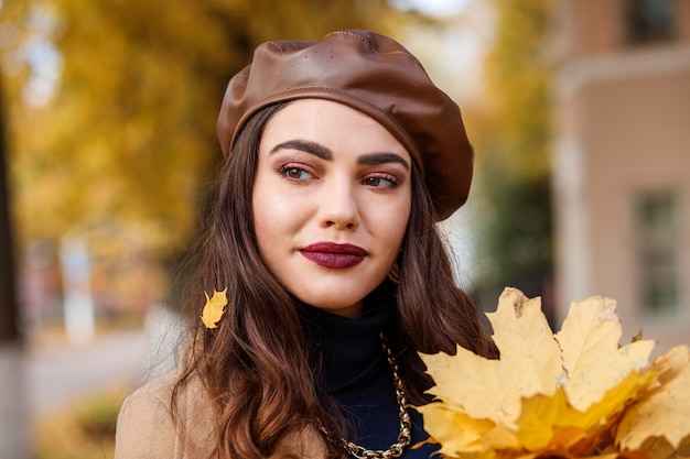 Portret van aantrekkelijke blanke vrouw in de herfst. Vrouw draagt lederen baret.