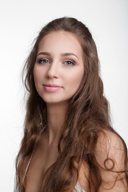 Portret van aantrekkelijke gelukkig brunette vrouw met natuurlijke make-up geïsoleerd op een witte achtergrond