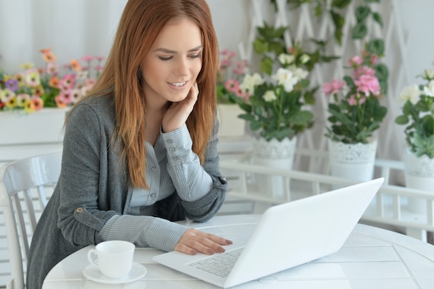 Portret van aantrekkelijke jonge vrouw die via laptop communiceert