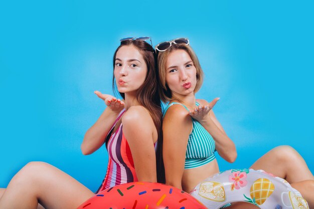 Portret van aantrekkelijke meisjes op het strand Twee gelukkige meisjes poseren in zwemkleding met een zonnebril Glimlachend en genietend van zomervakantie Summer Beach Sea