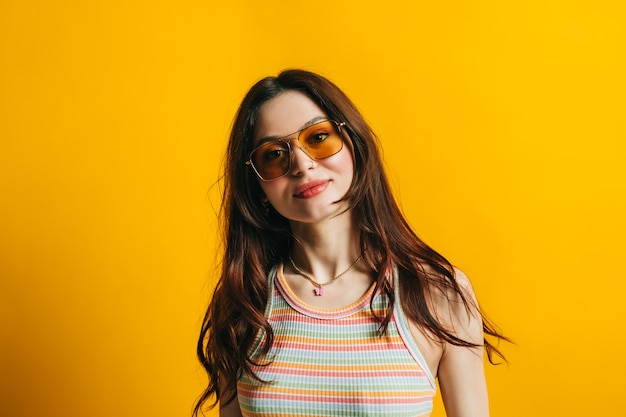 Portret van aantrekkelijke stijlvolle vrouw in zonnebril met lang donkerbruin haar