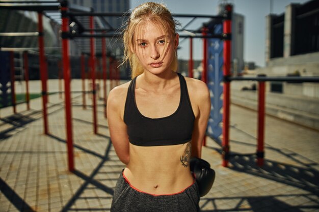 Portret van aantrekkelijke vrouw die klaar is met kickboksen training op sportveld