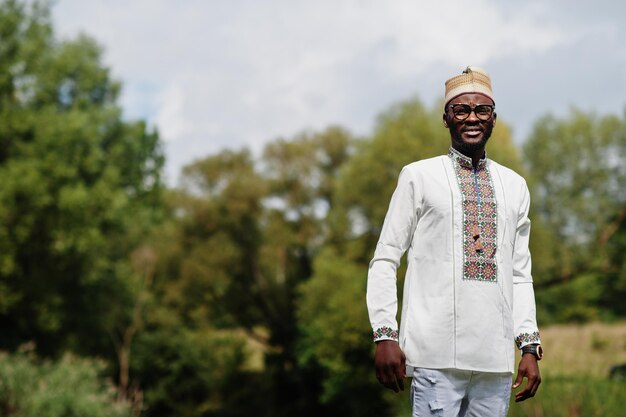 Foto portret van afrikaanse man in traditionele kleding in het park.