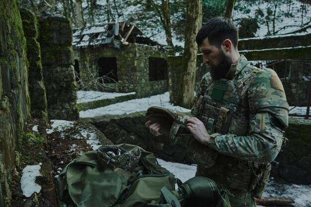 Portret van airsoft-speler in professionele uitrusting met machinegeweer in het bos. Soldaat met wapens in oorlog