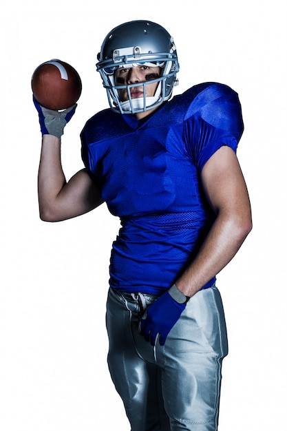 Portret van American football-speler in uniform gooien bal