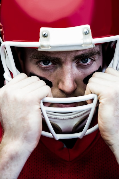 Foto portret van amerikaanse voetbalster die op zijn helm houdt