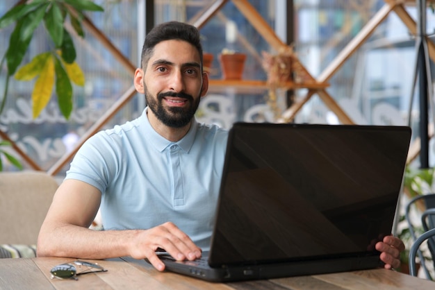 Portret van arabische jonge knappe gelukkige moslim bebaarde man met baard in vrijetijdskleding