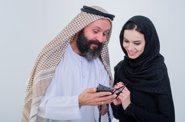 Portret van arabische manier gekleed paar spelen met mobiele telefoon.