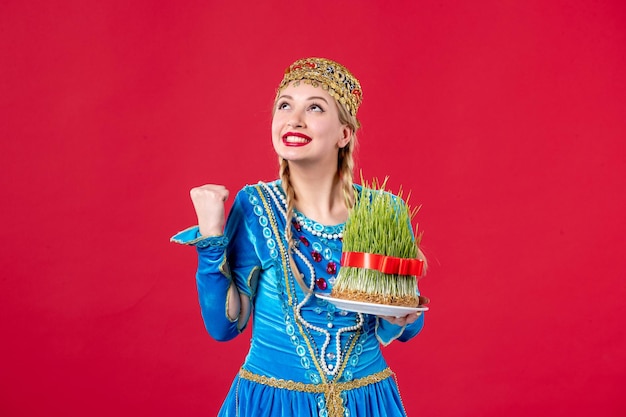 Portret van azeri vrouw in traditionele kleding met semeni studio shot rode achtergrond etnische novruz concept