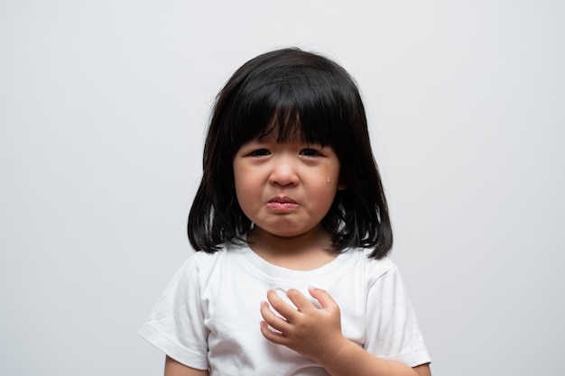 Portret van aziatische boos verdrietig en huilend meisje op een witte geïsoleerde achtergrond de emotie van een kind