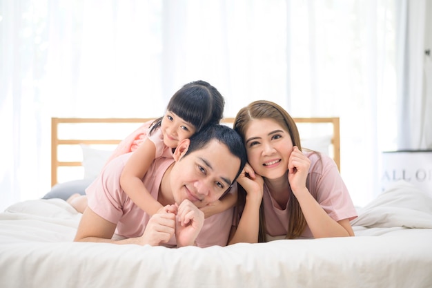 Portret van Aziatische en gelukkige familie in witte slaapkamer