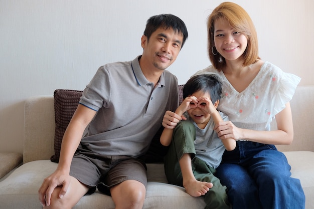 Portret van Aziatische Familiezitting op Bank samen.