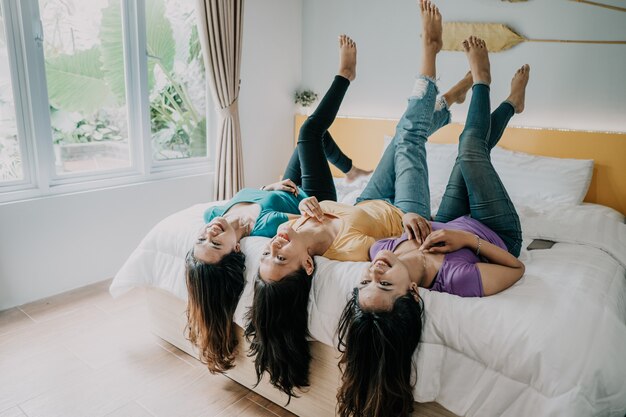 Portret van Aziatische gelukkige vriendschap op het bed. drie vriendinnen plezier samen in de slaapkamer