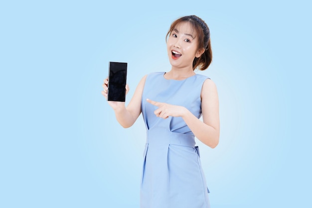 Portret van Aziatische jonge mooie en vrolijke vrouw met behulp van slimme telefoon geïsoleerd op studio kleur achtergrond