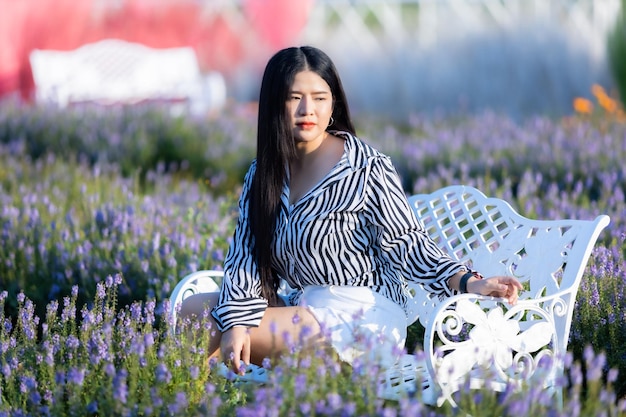 Portret van Aziatische jonge vrouw gelukkige reiziger met zwart-wit patroon jurk genieten in wit bloeiende bloem veld in de natuurtuin van in Thailandtravel ontspannen vakantie