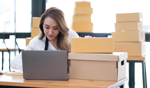 Portret van Aziatische jonge vrouw mkb werken met een doos thuis de werkplek opstarten kleine ondernemer kleine ondernemer mkb of freelance bedrijf online en levering concept