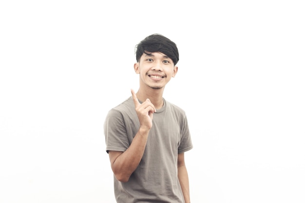 Portret van Aziatische jongeren die een grijs t-shirt dragen met een wijzende uitdrukking