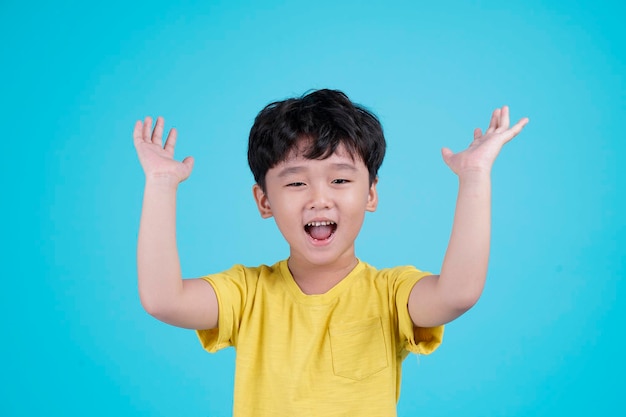 Portret van Aziatische knappe kleine jongen jongen geïsoleerd op blauwe achtergrond