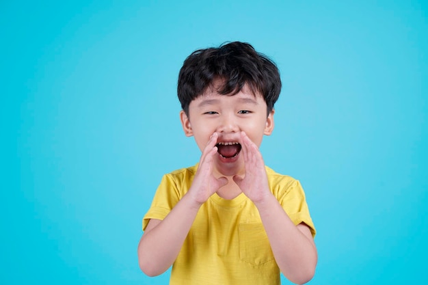 Portret van Aziatische knappe kleine jongen jongen geïsoleerd op blauwe achtergrond