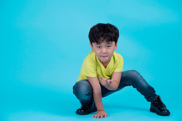 Portret van aziatische knappe kleine jongen jongen geïsoleerd op blauwe achtergrond