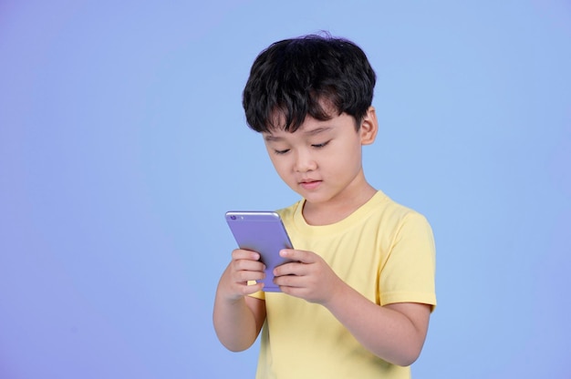 Portret van Aziatische knappe kleine jongen met behulp van slimme telefoon i