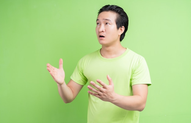 Portret van Aziatische man in groen t-shirt poseren op groen