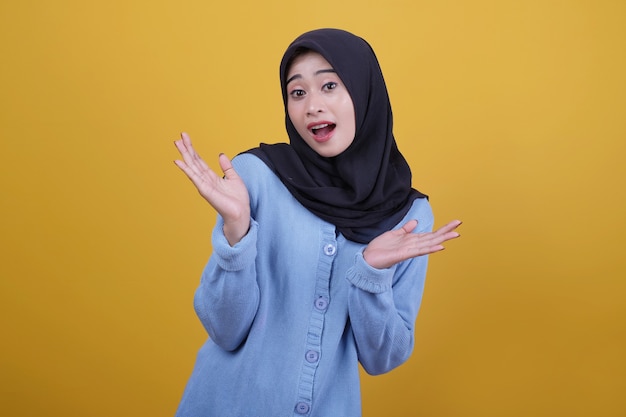 Portret van Aziatische mooie vrouw die zwarte hijab draagt, kijkt gelukkig uitdrukking die iets met twee handen toont