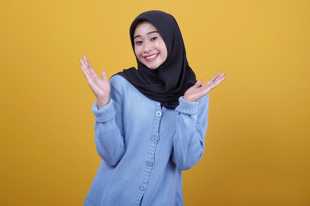 Portret van Aziatische mooie vrouw die zwarte hijab draagt, kijkt gelukkig uitdrukking die iets met twee handen toont