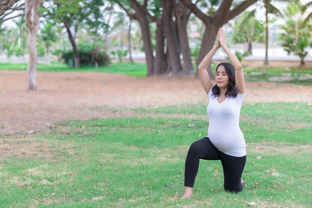 Portret van Aziatische mooie zwangere vrouw in het parkThailand mensen Gelukkig vrouwenconcept Haar spel yoga op het gazon