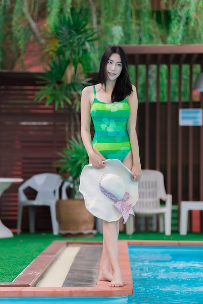 Portret van Aziatische sexy vrouw bij zwembad Thailand heeft een slanke lichaamsvorm Gezonde vrouw concept Mode bikini zomer