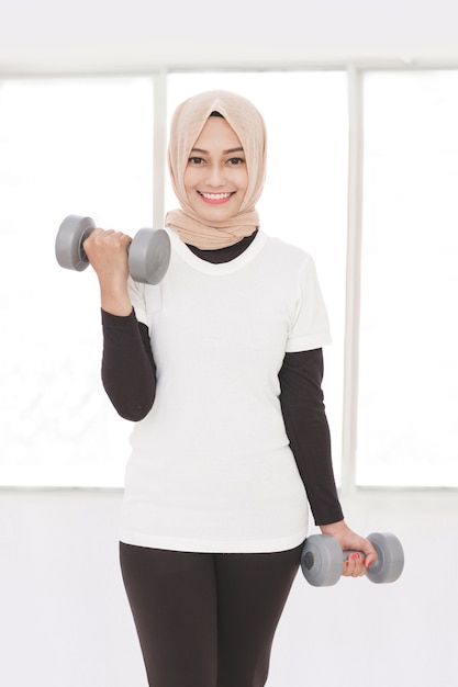 Portret van Aziatische sportieve vrouw tillen gewicht met behulp van halters