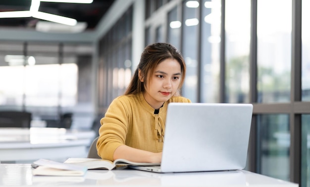 Portret van Aziatische studente die studeert aan de universiteitsbibliotheek